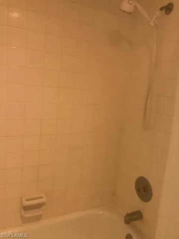 Details featuring tiled shower / bath combo