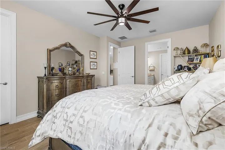 Primary bedroom with wood tiled floors and ceiling fan