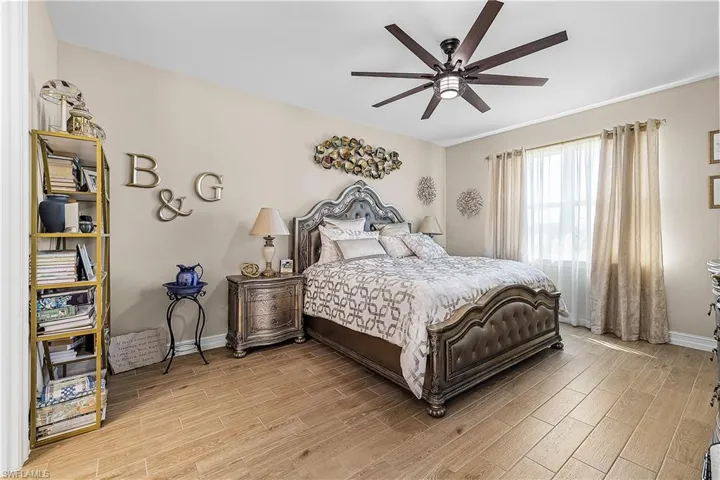 Primary bedroom with wood tiled floors and a ceiling fan