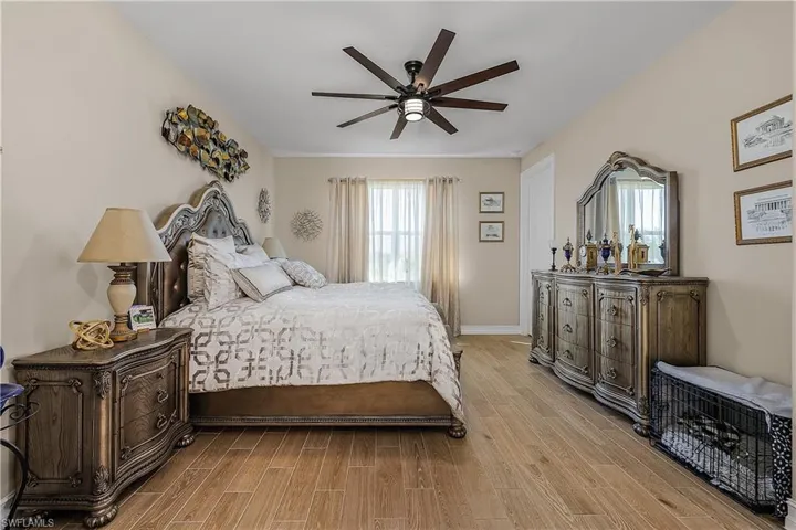 Primary bedroom featuring wood finish floors and a ceiling fan
