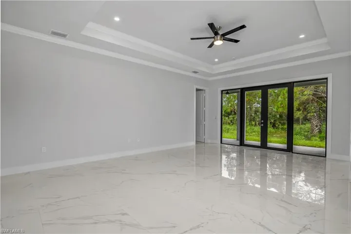 Empty room with ceiling fan, crown molding, french doors, light marble finish flooring, and recessed lighting