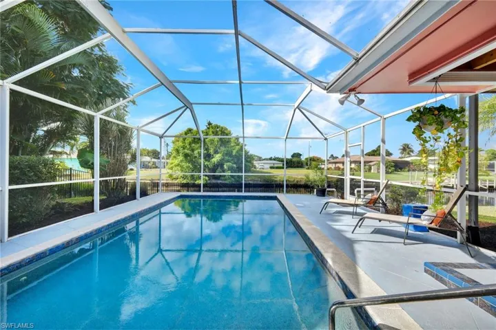 Outdoor pool featuring glass enclosure, a sunroom, and a patio