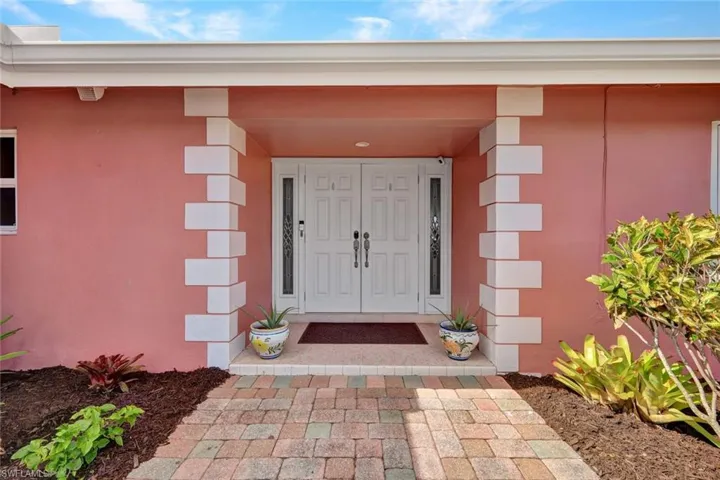 Entrance to property with stucco siding and covered porch