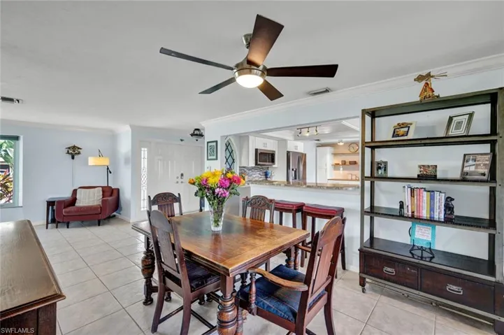 Dining space featuring crown molding, light tile patterned floors, and ceiling fan