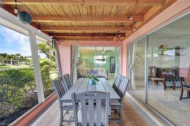 View of patio featuring outdoor dining space and a sunroom