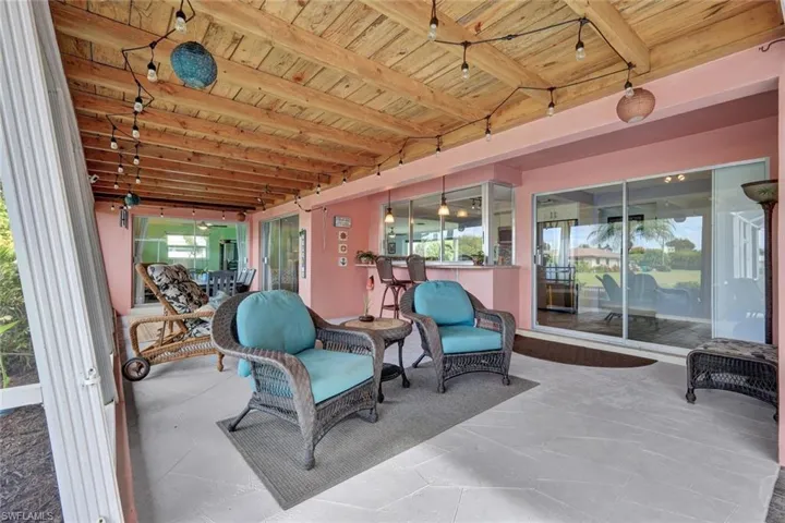 Sunroom / solarium with beamed ceiling and a patio area