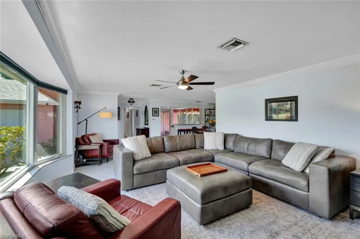 Living room featuring ornamental molding and a ceiling fan