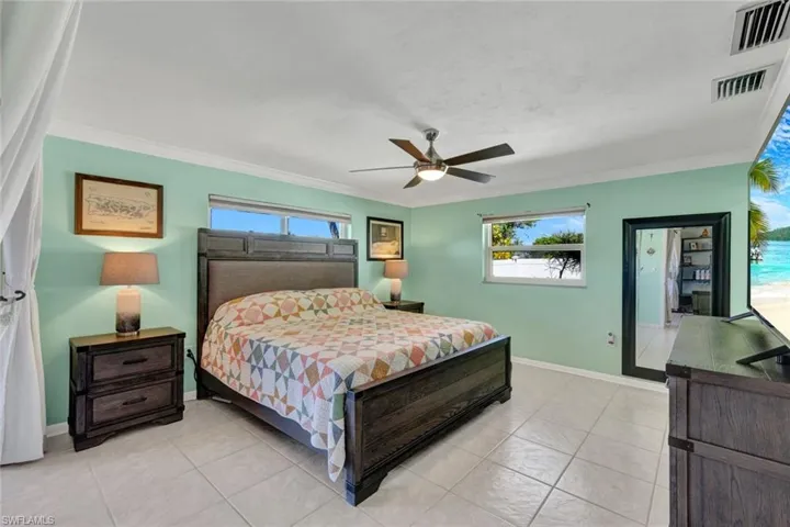 Bedroom featuring a ceiling fan, ornamental molding, and light tile patterned flooring