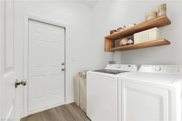 Laundry area with washer and clothes dryer and light hardwood / wood-style floors