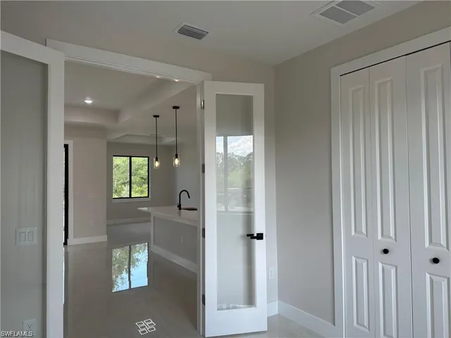 Corridor featuring sink and light tile patterned flooring