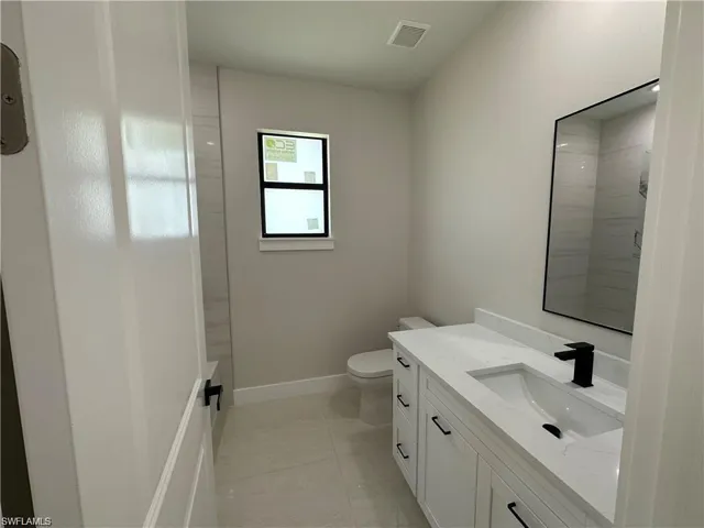 Full bathroom featuring tile patterned flooring, shower / washtub combination, toilet, and vanity