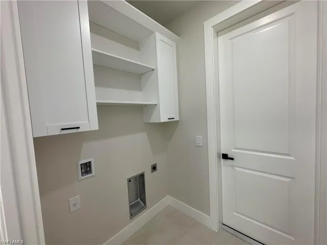 Washroom with hookup for an electric dryer, hookup for a washing machine, and light tile patterned floors