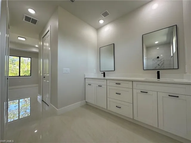 Bathroom with dual vanity and tile patterned flooring