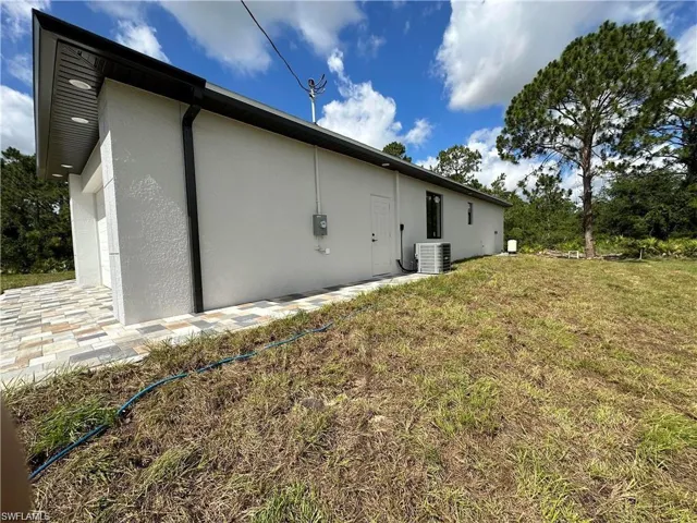 View of home's exterior with central air condition unit and a yard