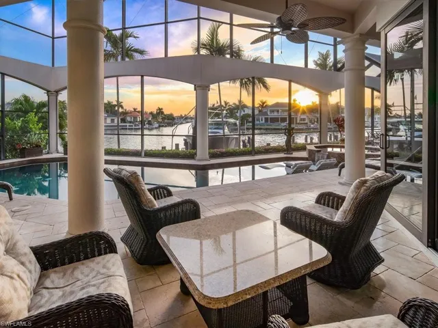 View of patio / terrace featuring ceiling fan, a water view, a sunroom, and a lanai