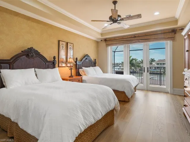 Bedroom with light wood-style flooring, ornamental molding, a water view, access to outside, and wallpapered walls
