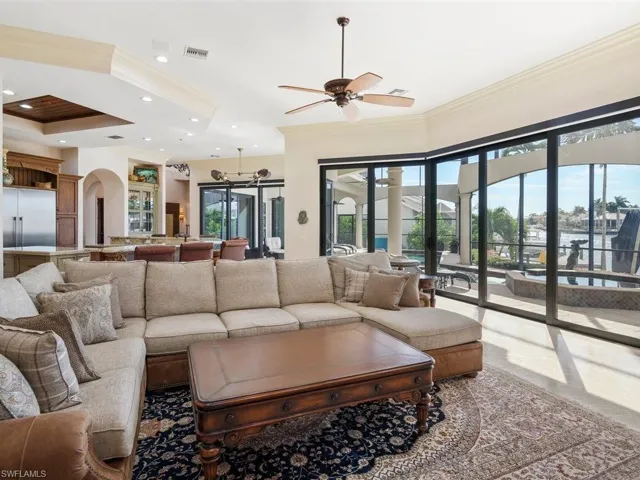 Living room with healthy amount of natural light, ornamental molding, arched walkways, ceiling fan, and recessed lighting