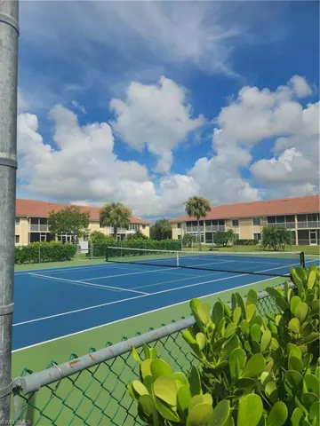 View of tennis court with community basketball court and fence