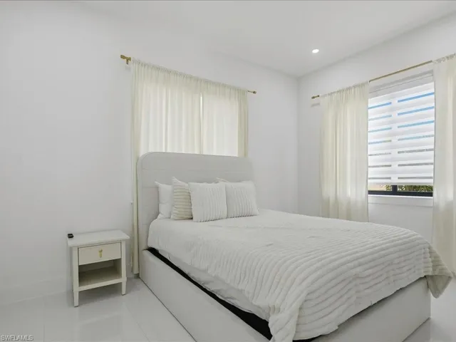Bright room featuring recessed lighting, a window with horizontal blinds and sheer curtains, and tile flooring