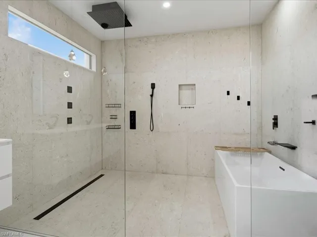 Contemporary bathroom featuring a spacious walk-in shower with matte black fixtures, a linear drain, and a rain shower head