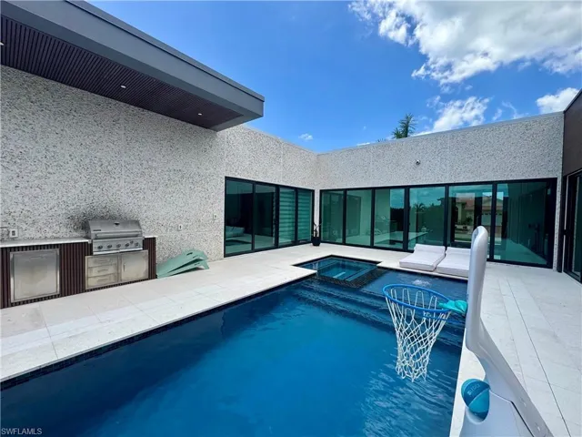 Modern outdoor space featuring a rectangular swimming pool with an integrated spa