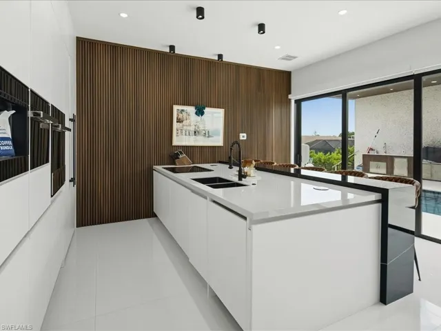Contemporary kitchen featuring an expansive center island with integrated sinks and a matte black faucet
