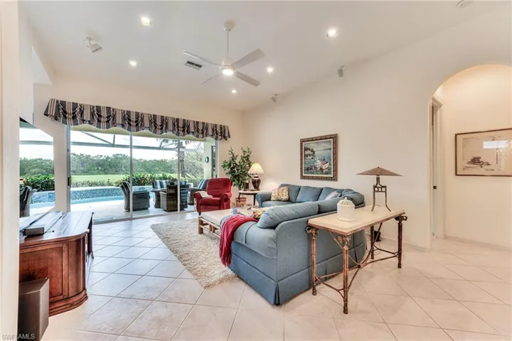 Living room with ceiling fan and light tile patterned floors