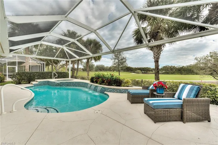 View of pool featuring pool water feature, a lanai, a patio, and an in ground hot tub