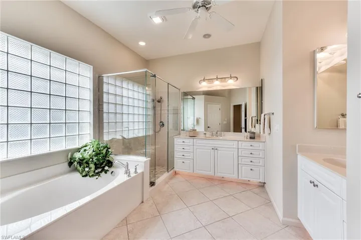 Bathroom featuring ceiling fan, shower with separate bathtub, tile patterned floors, and vanity