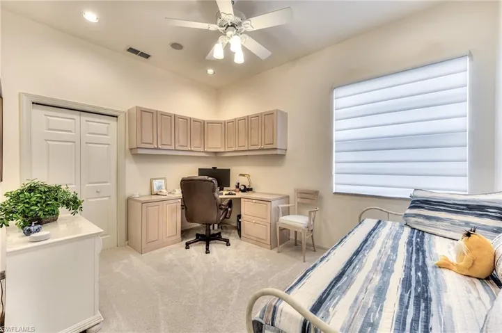 Bedroom featuring light carpet, ceiling fan, and a closet