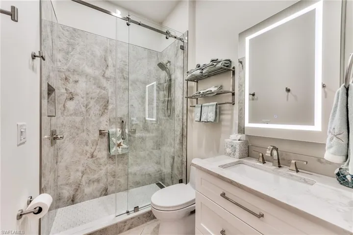 Bathroom with walk in shower, vanity, and toilet