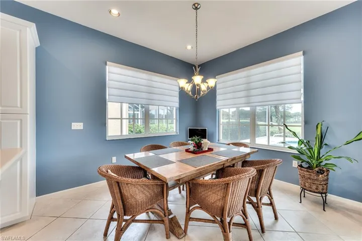 Tiled dining area featuring plenty of natural light and a chandelier