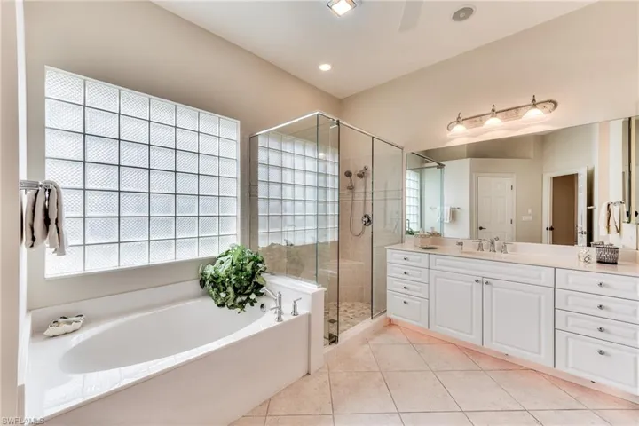 Bathroom with vanity, independent shower and bath, and tile patterned flooring