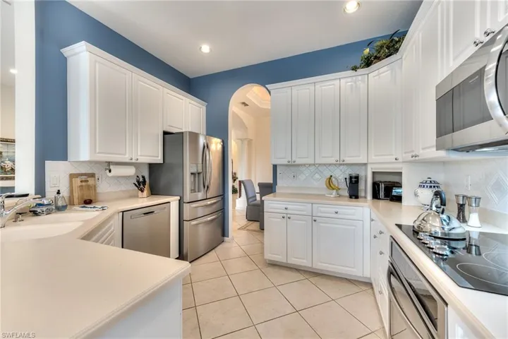 Kitchen with stainless steel appliances, white cabinets, and sink