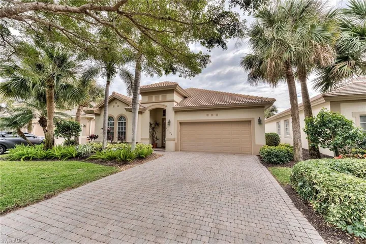 Mediterranean / spanish-style home with a garage and a front yard