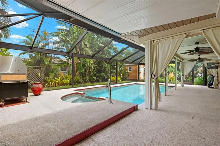 View of pool featuring ceiling fan, area for grilling, a patio, and a lanai