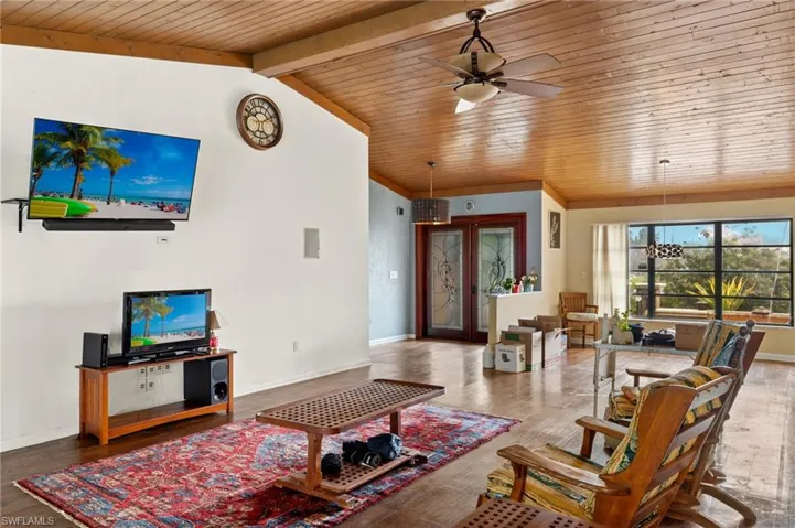 Living room featuring hardwood / wood-style floors, french doors, wooden ceiling, vaulted ceiling, and ceiling fan