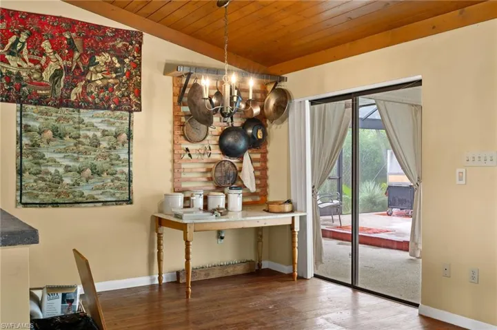 Dining area featuring wooden ceiling, lofted ceiling, a chandelier, and dark hardwood / wood-style floors