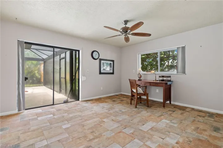 Office space with a textured ceiling, ceiling fan, and light tile patterned floors