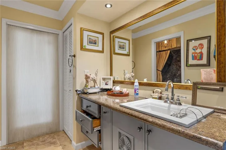Bathroom with tile patterned floors, vanity, and ornamental molding