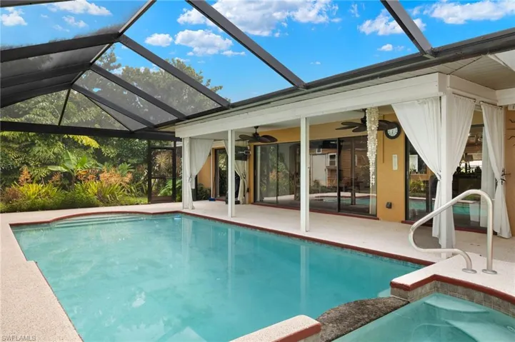 View of swimming pool with a patio area, a lanai, and ceiling fan