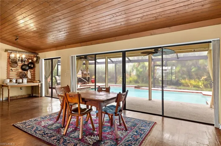 Dining space featuring hardwood / wood-style flooring, plenty of natural light, lofted ceiling, and wood ceiling