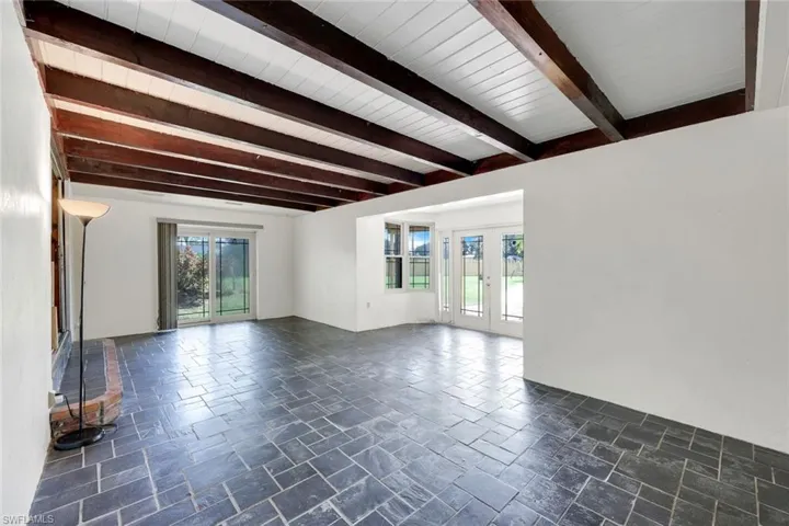 Unfurnished living room with plenty of natural light and beam ceiling