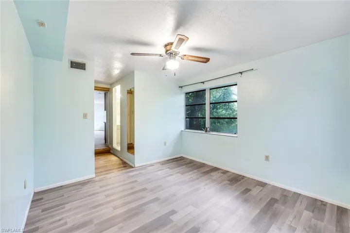 Spare room featuring light wood-type flooring, ceiling fan, and a textured ceiling