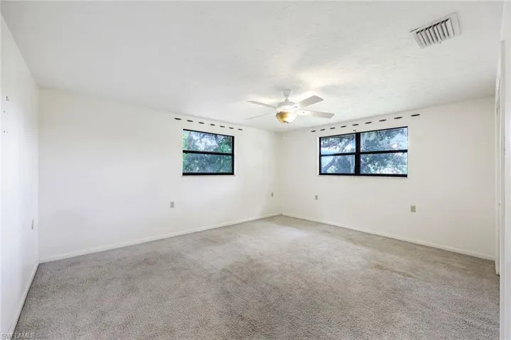 Unfurnished room with light colored carpet and ceiling fan