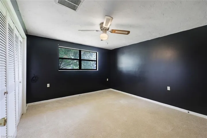 Unfurnished bedroom with a closet, ceiling fan, light colored carpet, and a textured ceiling