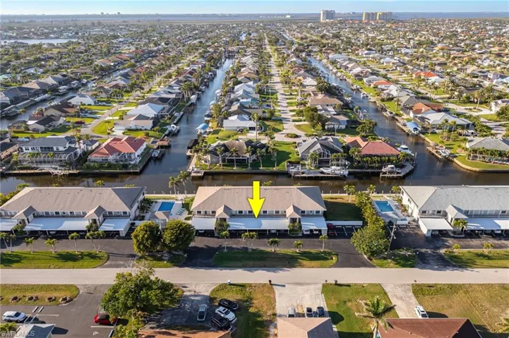 Aerial view of property and surrounding area with nearby suburban area and a large body of water