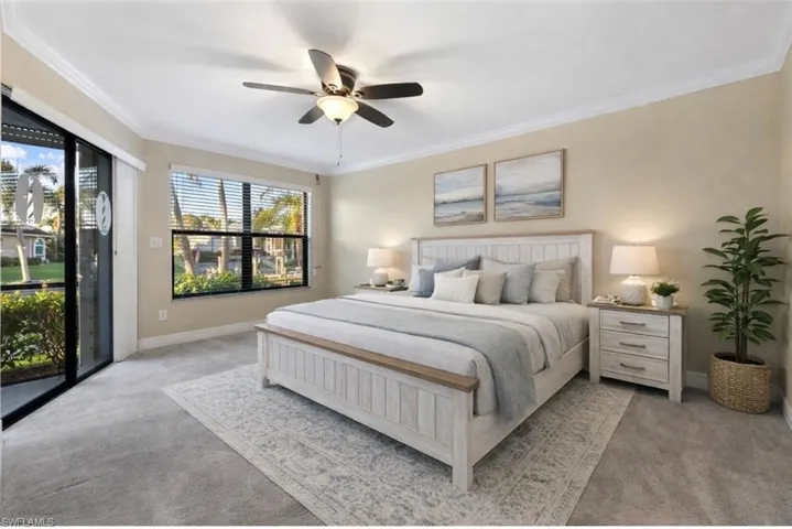 Virtually staged Bedroom featuring access to exterior, carpet flooring, crown molding, and a ceiling fan