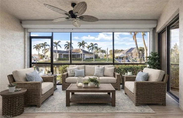 Virtually staged Sunroom / solarium featuring a textured wall, wood finished floors, plenty of natural light, and a textured ceiling