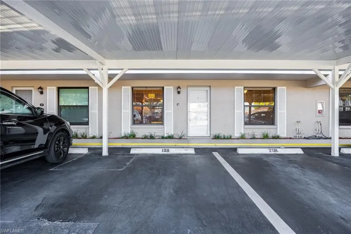 View of exterior entry featuring uncovered parking and stucco siding